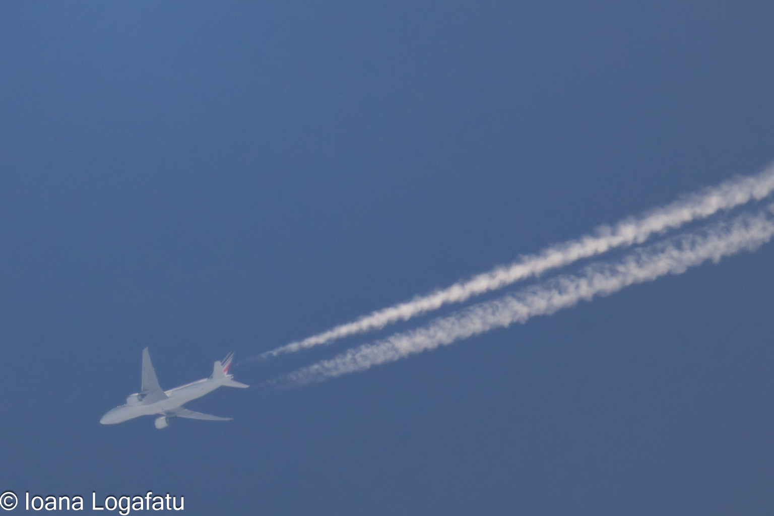Plane soaring through a clear blue sky